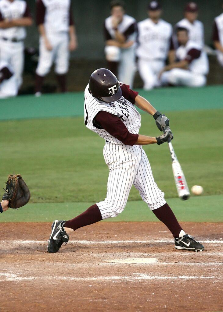 Baseball player in pinstriped uniform swinging a bat with a ball approaching