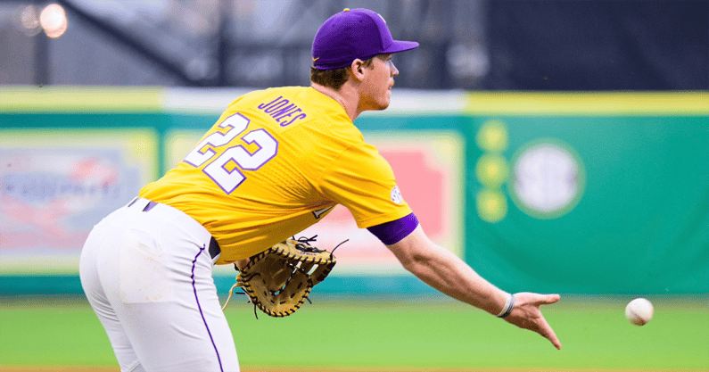 Baseball player in yellow jersey reaching for a ball with a glove