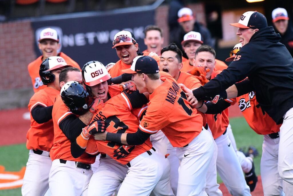 Group of baseball players in orange uniforms celebrating together on the field