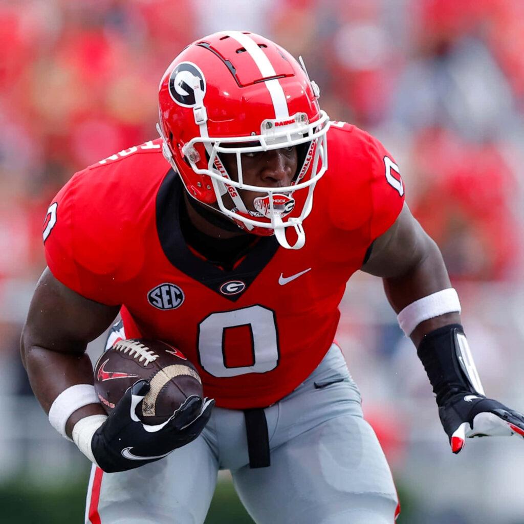 Football player in red uniform carrying the ball during a game